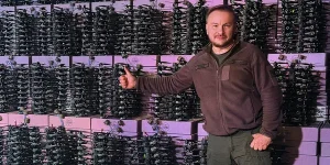 Сергій Бескрестнов демонструє FPV-дрон на тлі арсеналу для ударів