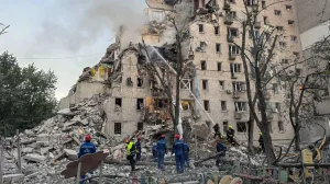 Рятувальники працюють біля зруйнованої багатоповерхівки з димом у Києві