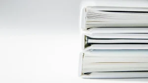 Стопка білих книг із видимими сторінками на білому тлі