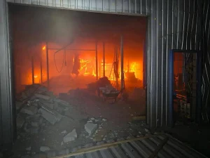 Пожежа всередині зруйнованого складського приміщення з димом уламками та вогнем