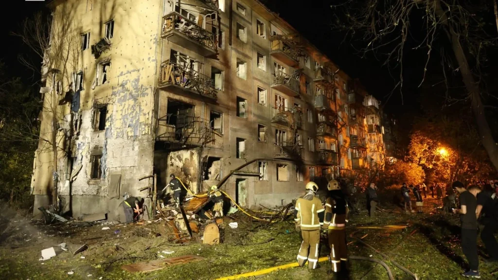 Пожежники працюють біля зруйнованого житлового будинку в Києві вночі